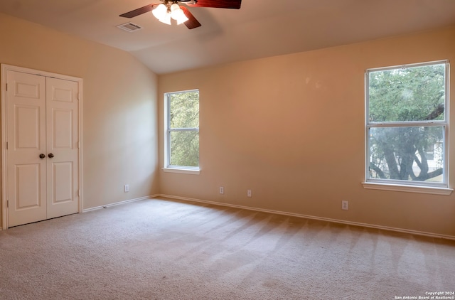 unfurnished room featuring vaulted ceiling, light colored carpet, and ceiling fan