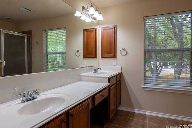 bathroom with vanity, a shower with shower door, and tile patterned floors