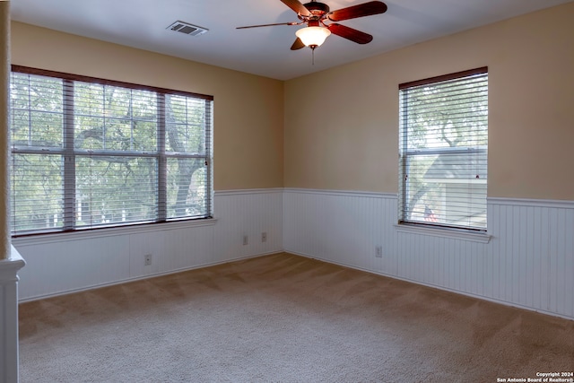 spare room with light colored carpet and ceiling fan