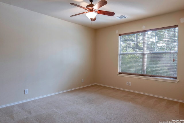 carpeted spare room with ceiling fan