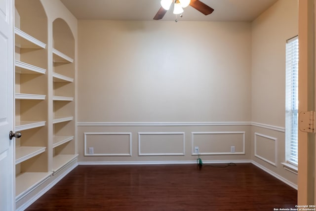10707 Axis Xing, San Antonio, TX 78245 - empty room with dark wood-style flooring, a ceiling fan, a wainscoted wall, and a decorative wall