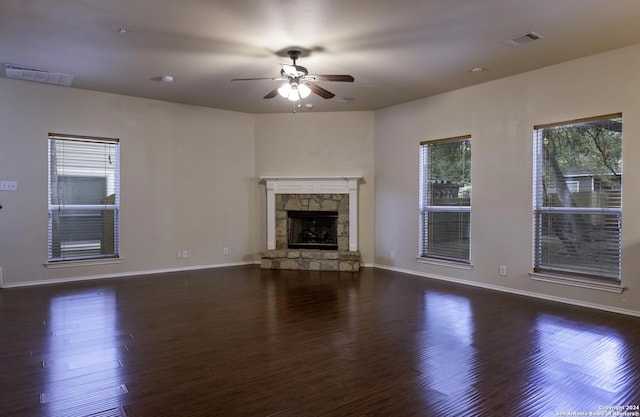 10707 Axis Xing, San Antonio, TX 78245 - unfurnished living room with ceiling fan, dark wood-type flooring, baseboards, and a fireplace