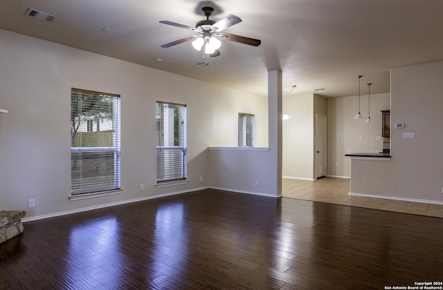 10707 Axis Xing, San Antonio, TX 78245 - unfurnished living room with ceiling fan, wood finished floors, and baseboards