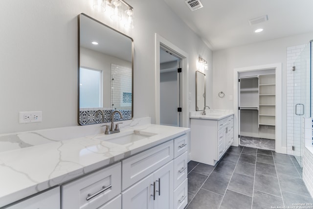 bathroom with walk in shower, vanity, and tile patterned floors