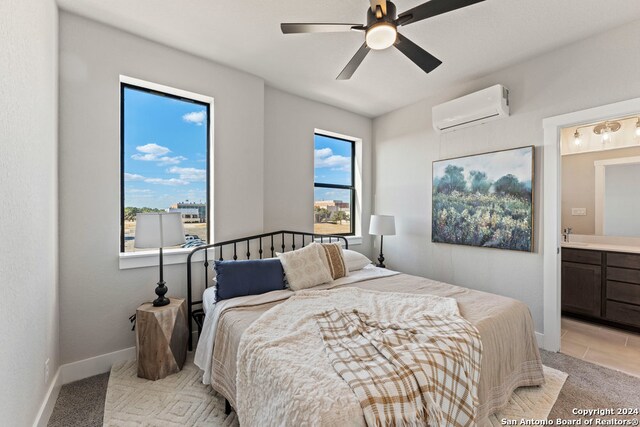 bedroom with ensuite bath, a wall mounted AC, light colored carpet, and ceiling fan