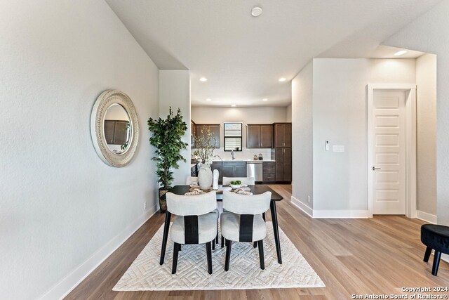 dining room featuring sink and light hardwood / wood-style flooring