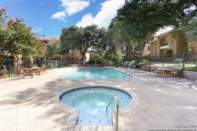 view of pool featuring a patio area and a hot tub