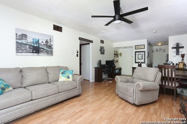 living room with light hardwood / wood-style floors and ceiling fan