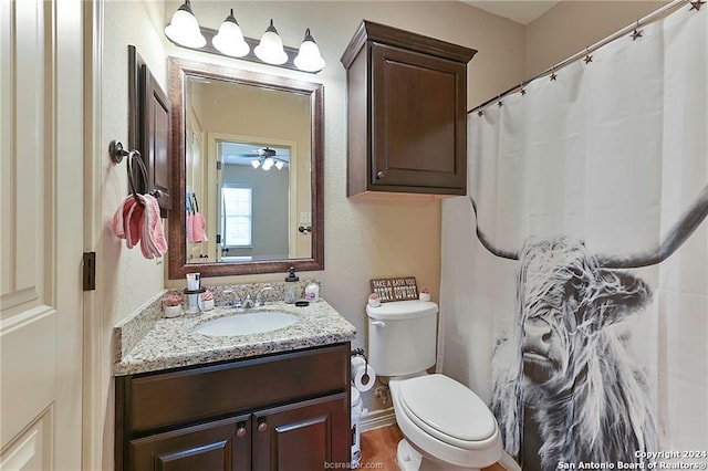 bathroom featuring vanity, toilet, wood-type flooring, and ceiling fan