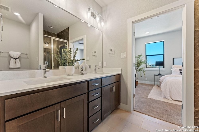 7942 Kennedy Hl Unit 8, San Antonio, TX 78235 - bathroom featuring a shower stall, double vanity, ensuite bathroom, tile patterned flooring, and baseboards