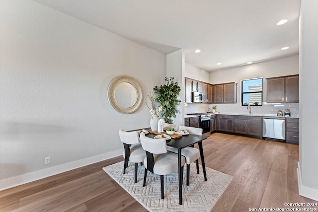 dining space featuring hardwood / wood-style floors and sink