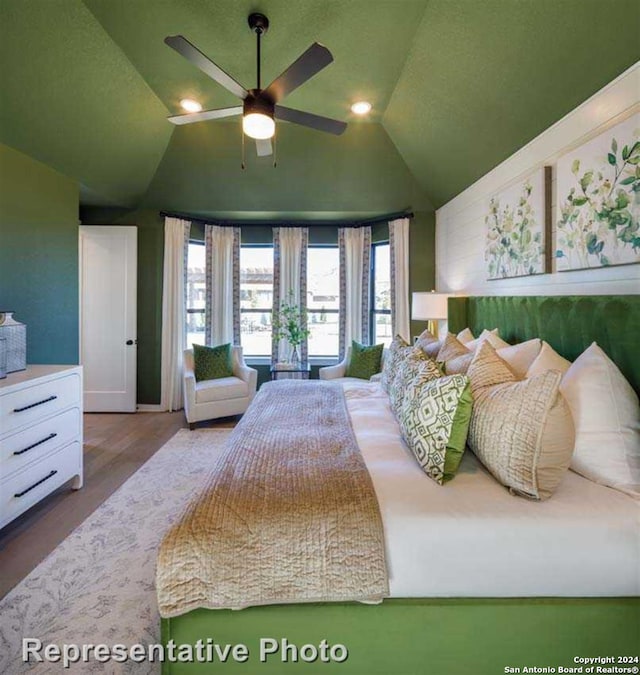 bedroom with lofted ceiling, hardwood / wood-style flooring, and ceiling fan