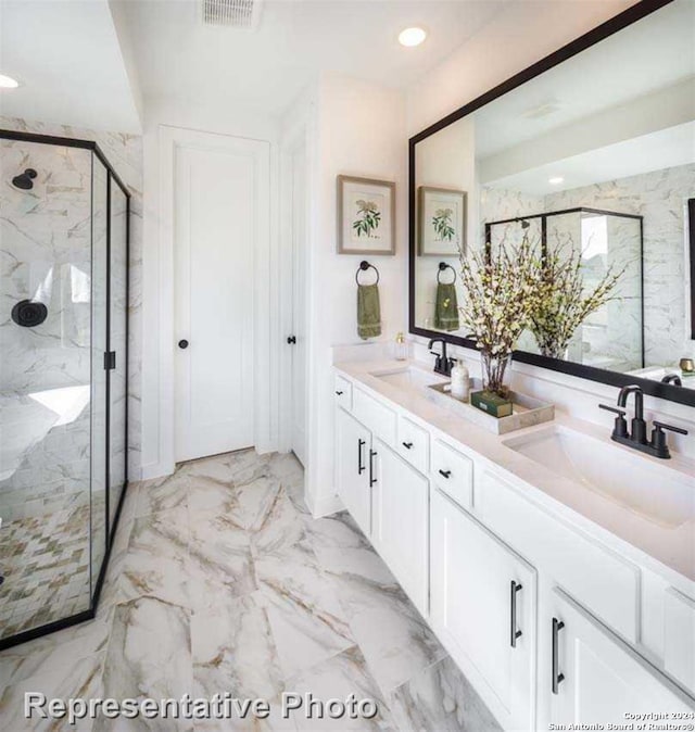 bathroom featuring a shower with shower door and vanity