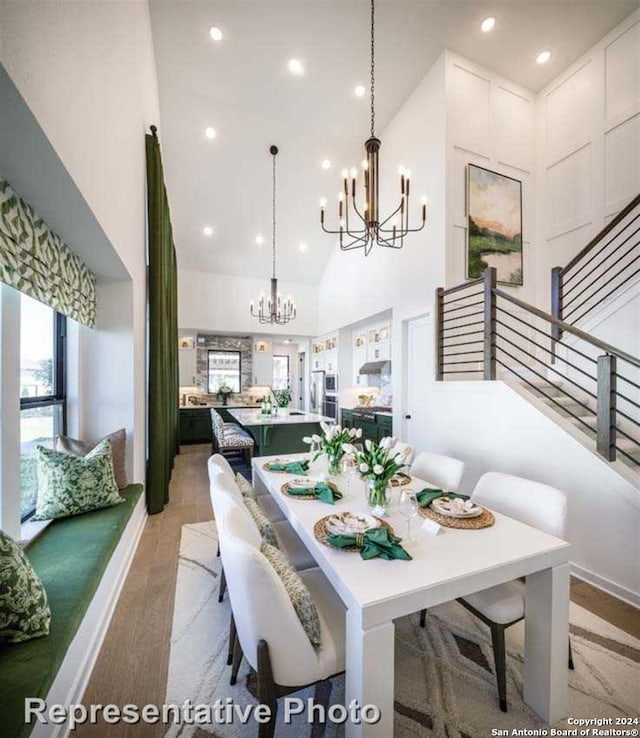 dining space featuring light wood-type flooring and high vaulted ceiling