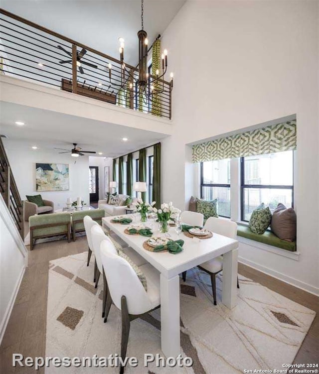 dining room with hardwood / wood-style floors, a high ceiling, and ceiling fan