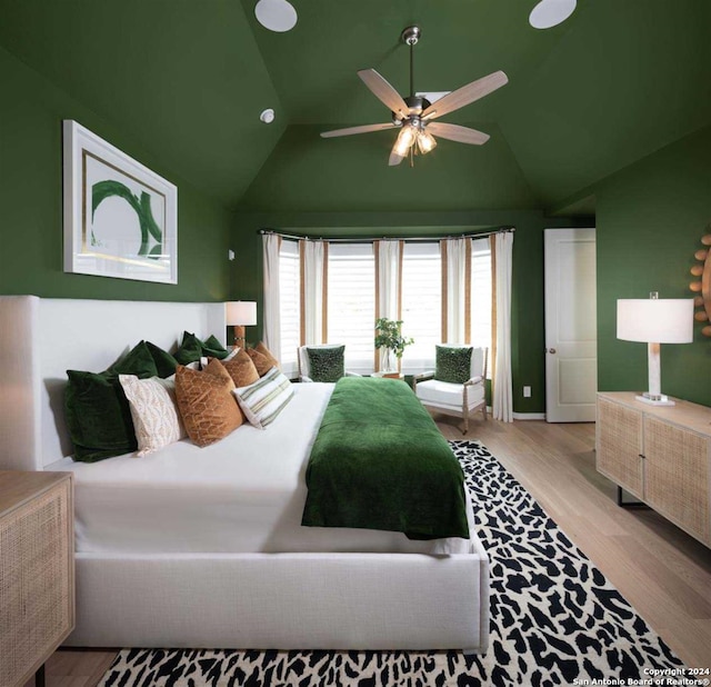 bedroom featuring ceiling fan, light hardwood / wood-style flooring, and lofted ceiling