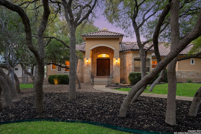 mediterranean / spanish house with a lawn