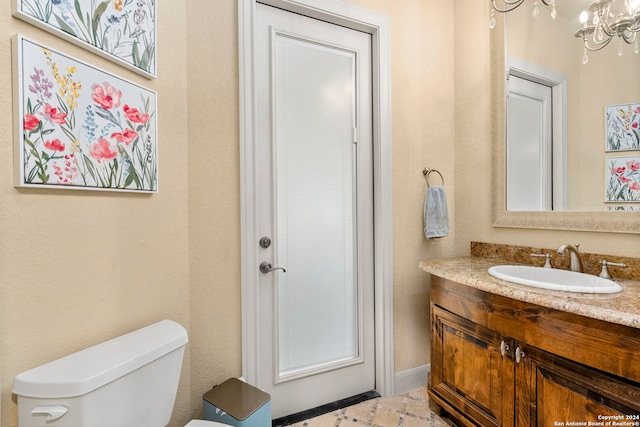 bathroom featuring a chandelier, vanity, and toilet