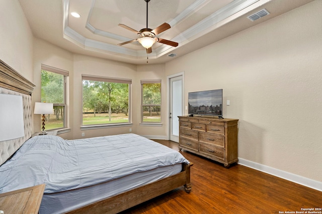 bedroom featuring crown molding, dark hardwood / wood-style flooring, ceiling fan, and a raised ceiling