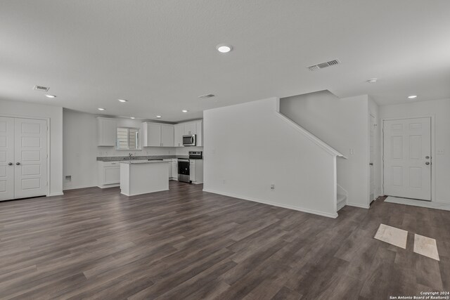 unfurnished living room with dark wood-type flooring