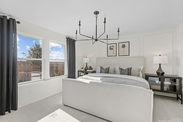 bedroom featuring a chandelier and light colored carpet