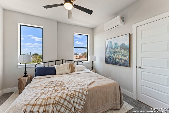 bedroom with ceiling fan, an AC wall unit, and carpet