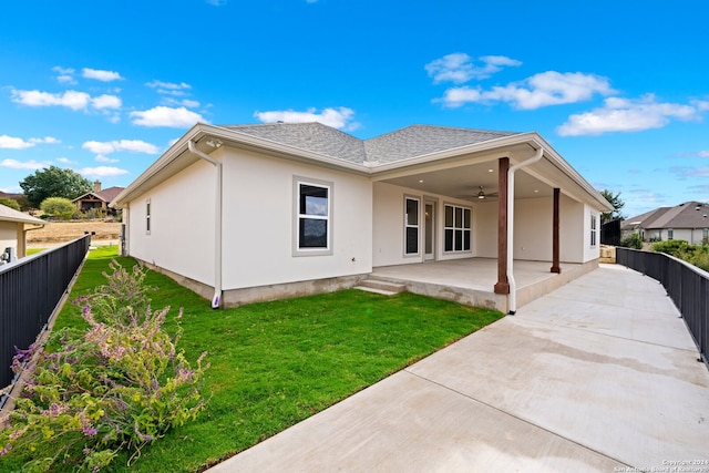 rear view of house featuring ceiling fan, a yard, and a patio