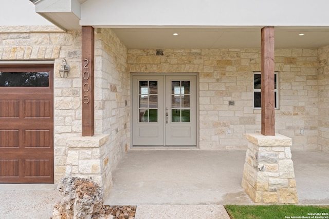 property entrance with a garage and french doors