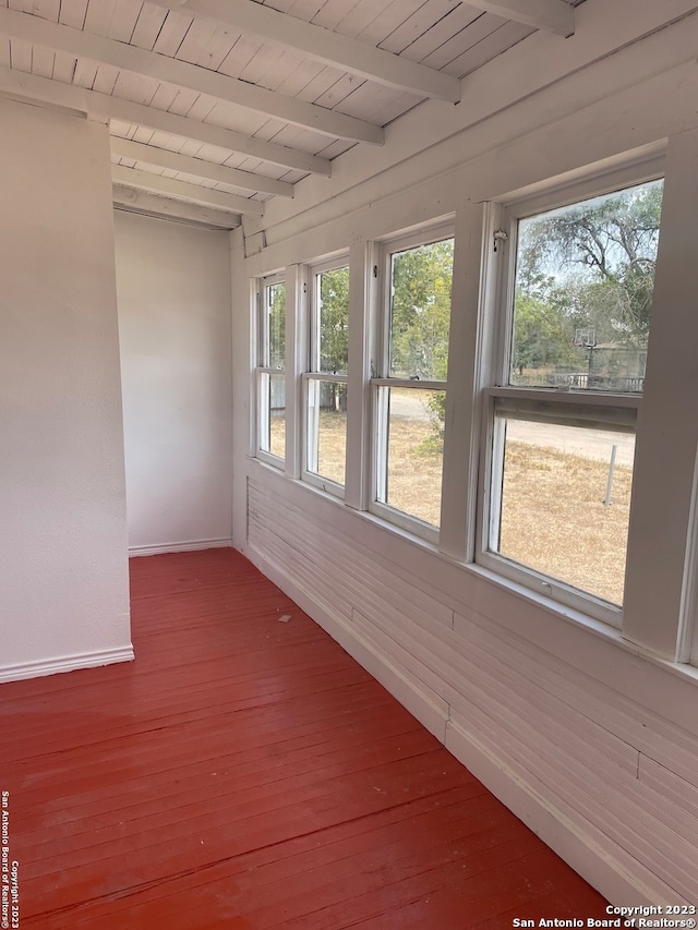 unfurnished sunroom featuring beamed ceiling and wooden ceiling