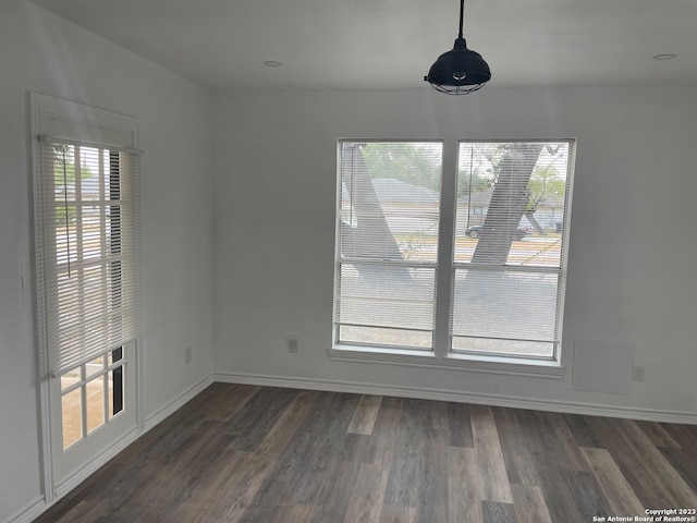 unfurnished dining area featuring dark wood-type flooring and plenty of natural light