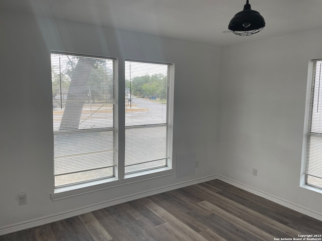 empty room with plenty of natural light and dark hardwood / wood-style floors