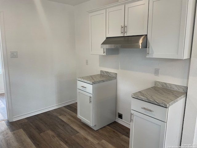 kitchen with light stone countertops, dark hardwood / wood-style flooring, and white cabinets