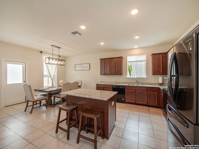 kitchen with black dishwasher, a center island, stainless steel fridge, pendant lighting, and light tile patterned floors