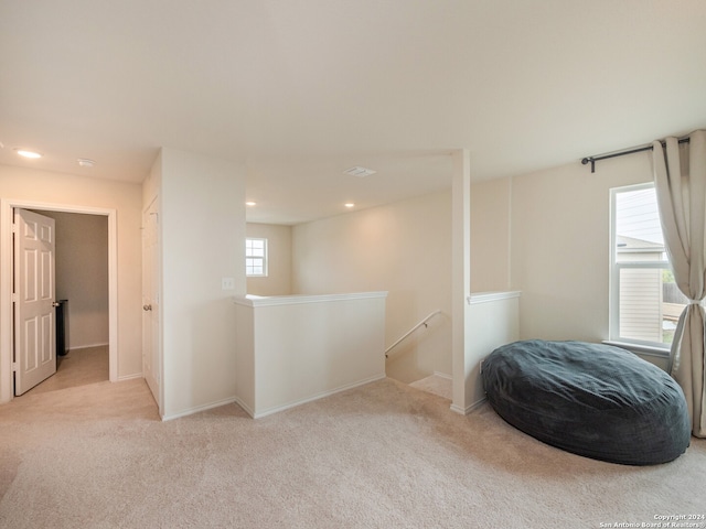 living area featuring light carpet