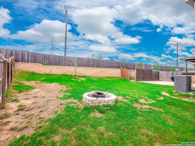 view of yard featuring an outdoor fire pit, cooling unit, and a patio