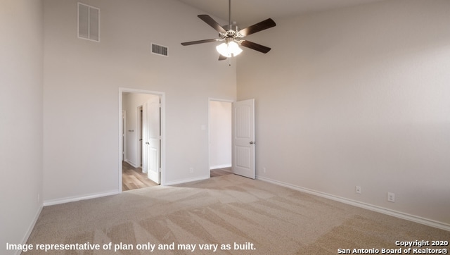 unfurnished bedroom featuring light colored carpet, high vaulted ceiling, and ceiling fan