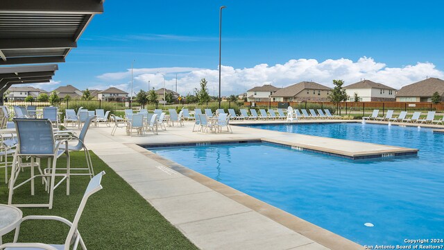 view of pool with a patio and a lawn