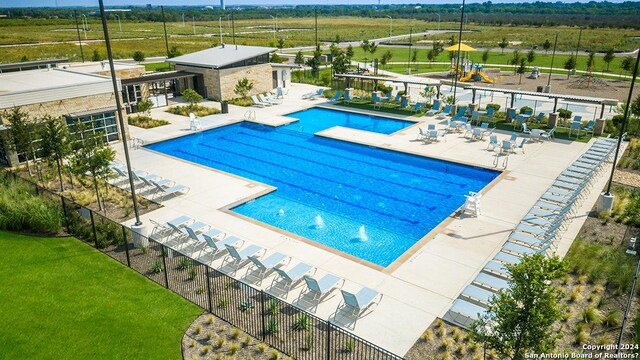 view of pool with a patio and a yard