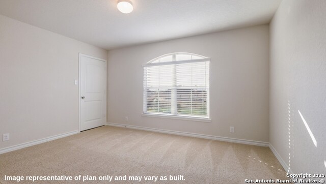 empty room with a wealth of natural light and light colored carpet