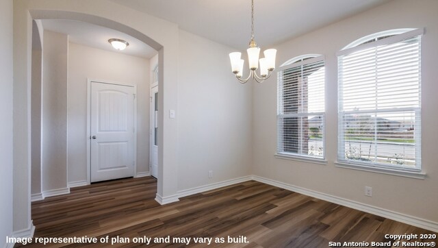 unfurnished room featuring dark hardwood / wood-style floors and a chandelier