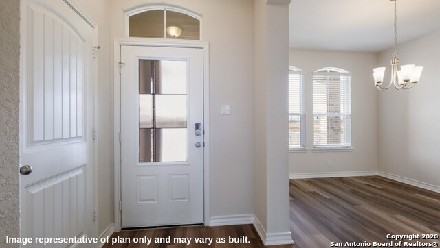 entryway with a notable chandelier and dark hardwood / wood-style flooring