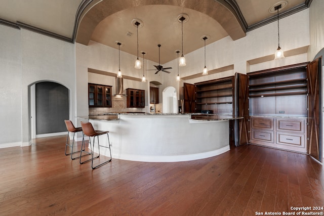 kitchen featuring dark hardwood / wood-style flooring, high vaulted ceiling, and pendant lighting