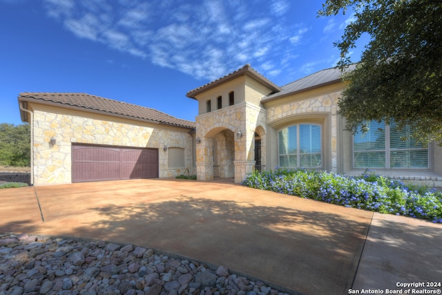 mediterranean / spanish home featuring a garage