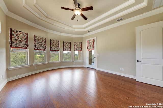 unfurnished room featuring hardwood / wood-style floors, a tray ceiling, and a wealth of natural light