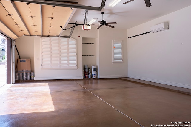 garage featuring an AC wall unit, a garage door opener, and ceiling fan