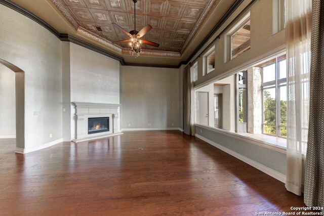 unfurnished living room featuring ornamental molding, dark wood-type flooring, and ceiling fan