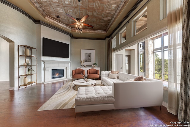 living room featuring crown molding, dark wood-type flooring, and ceiling fan