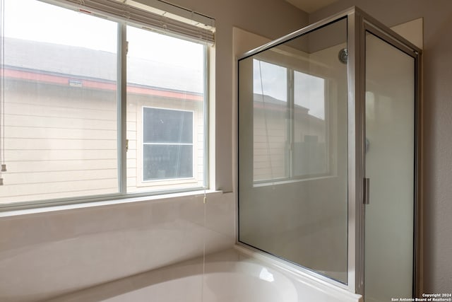 bathroom featuring a wealth of natural light and separate shower and tub