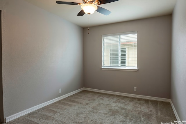 carpeted spare room with ceiling fan