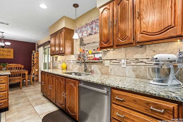 kitchen featuring dishwasher, light stone countertops, sink, and hanging light fixtures